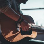 Photo by Jacek Dylag man playing acoustic guitar selective focus photography