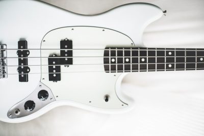 white and black electric bass guitar